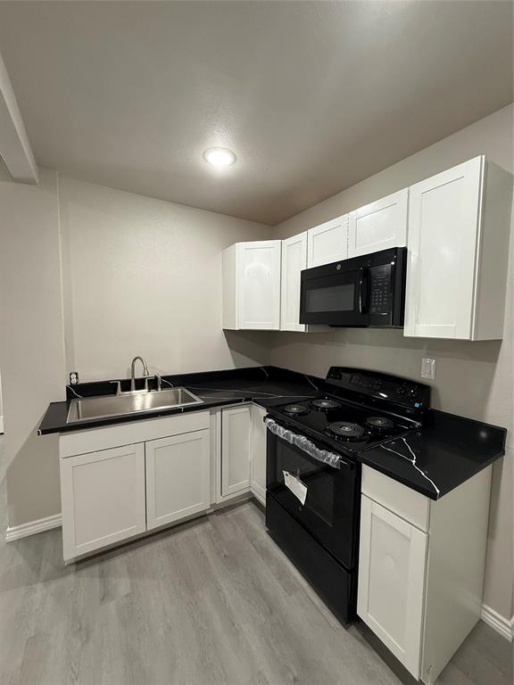 4812 Barbara Road River Oaks, TX 76114 - Photo 14 of 20 a kitchen with granite countertop white cabinets and black appliances