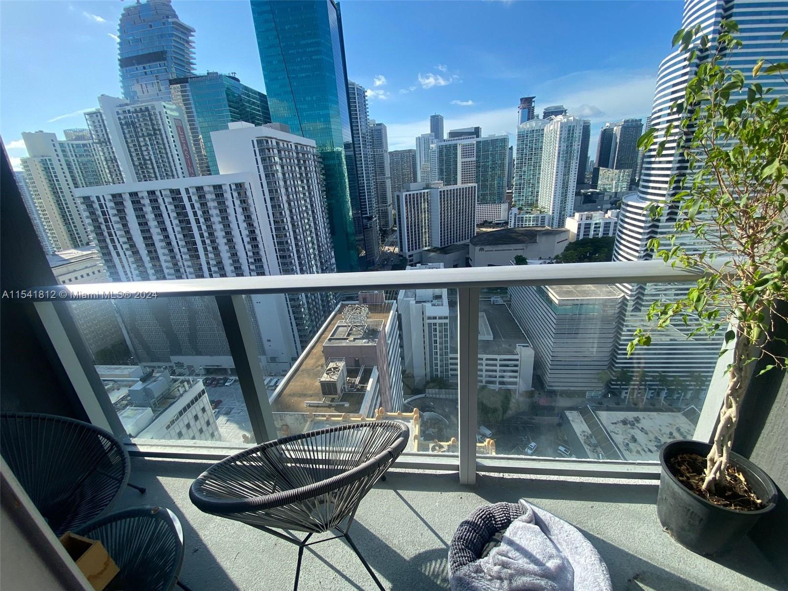 151 Southeast 1st Street, Unit 2707 Miami, FL 33131 - Photo 2 of 12 a view of a balcony with chair and potted plants