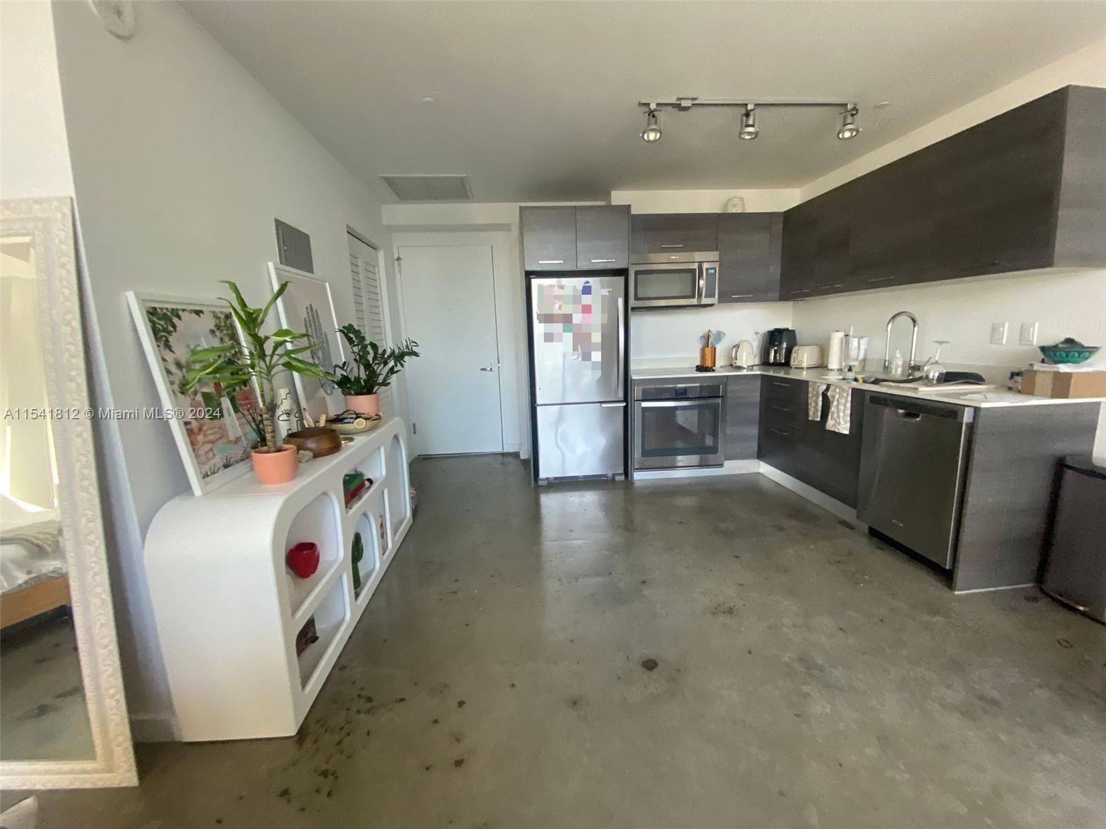 151 Southeast 1st Street, Unit 2707 Miami, FL 33131 - Photo 3 of 12 a living room with stainless steel appliances furniture a flat screen tv and a refrigerator