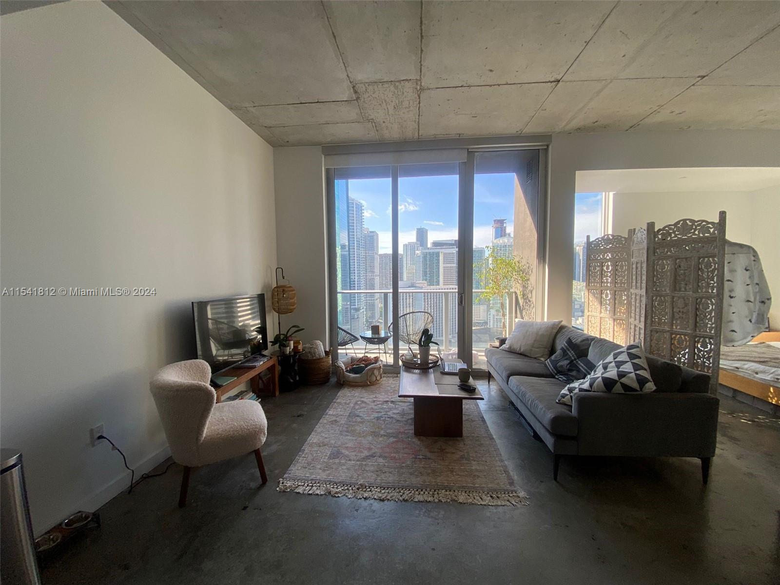 151 Southeast 1st Street, Unit 2707 Miami, FL 33131 - Photo 4 of 12 a living room with furniture and a large window