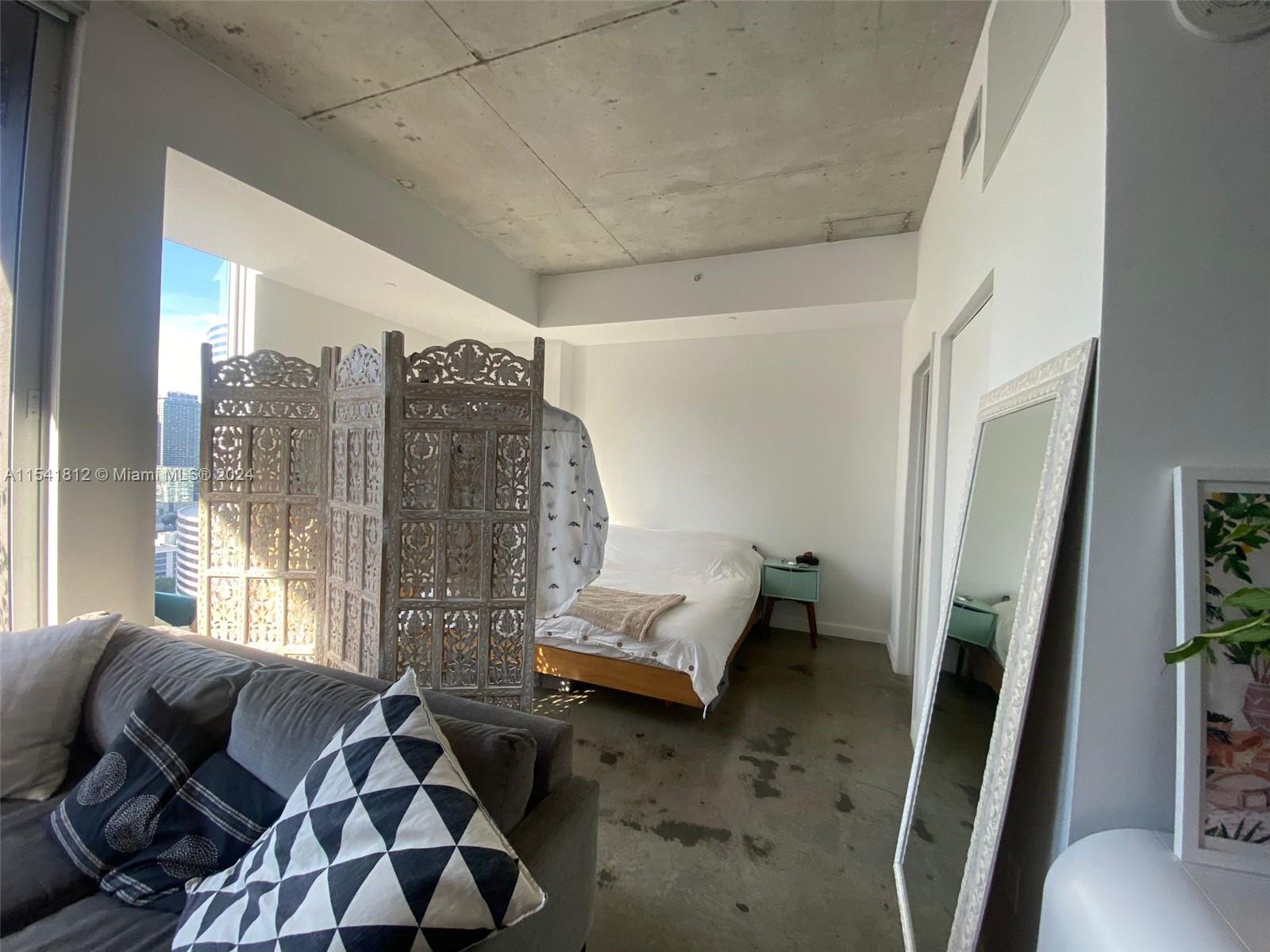 151 Southeast 1st Street, Unit 2707 Miami, FL 33131 - Photo 5 of 12 a living room with furniture and a large window