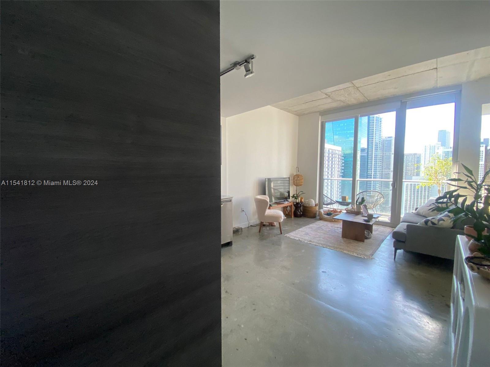 151 Southeast 1st Street, Unit 2707 Miami, FL 33131 - Photo 7 of 12 a living room with furniture and a large window