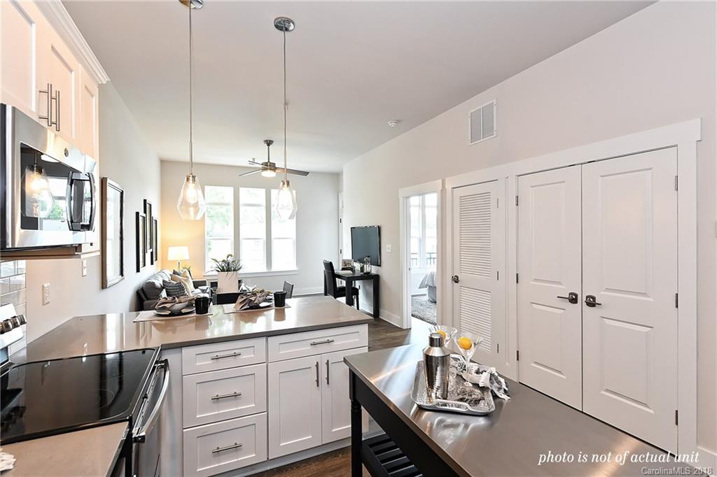 935 McAlway Road, Unit 201 Charlotte, NC 28211 - Photo 4 of 21 a kitchen with a sink dishwasher a dining table and chairs with wooden floor