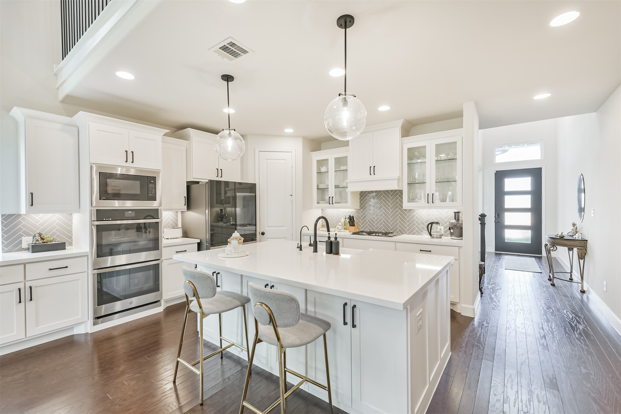 19319 Wild Sabino Way Tomball, TX 77377 - Photo 13 of 46 a kitchen with stainless steel appliances kitchen island granite countertop a table chairs and a stove