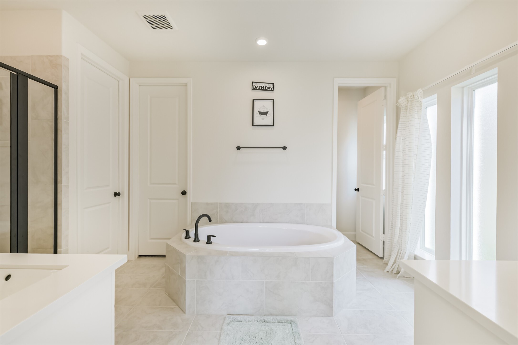 19319 Wild Sabino Way Tomball, TX 77377 - Photo 22 of 46 a white bath tub sitting in a en suite bathroom
