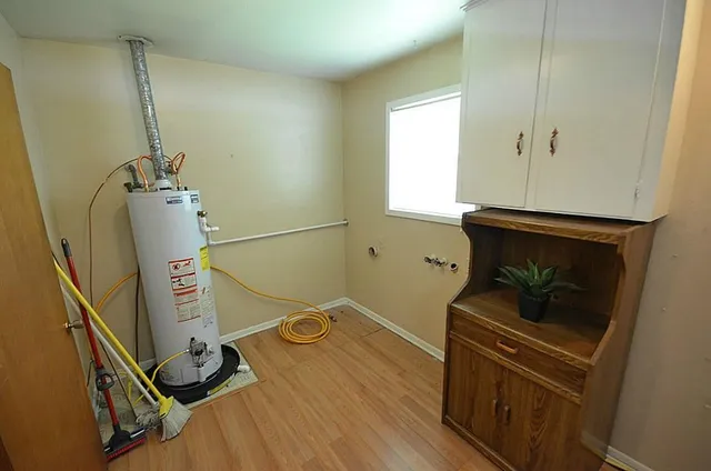 an empty room with chandelier fan and windows
