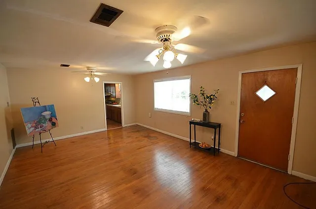 wooden floor in an empty room with a window