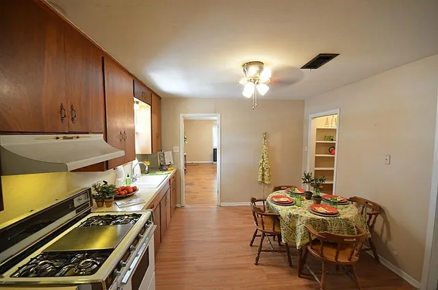 a kitchen with granite countertop wooden floors and wooden cabinets