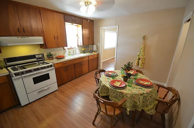 a kitchen with stainless steel appliances wooden floors and wooden cabinets