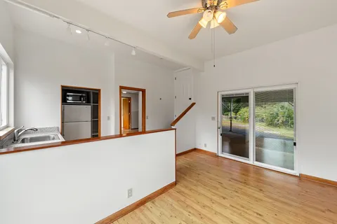 a view of a kitchen with wooden floor and a ceiling fan
