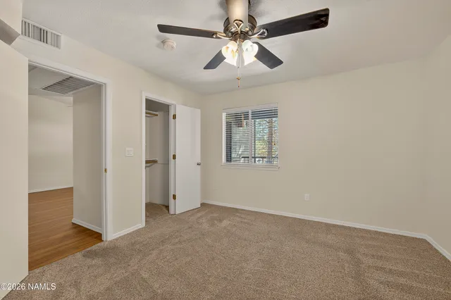an empty room with fan and windows