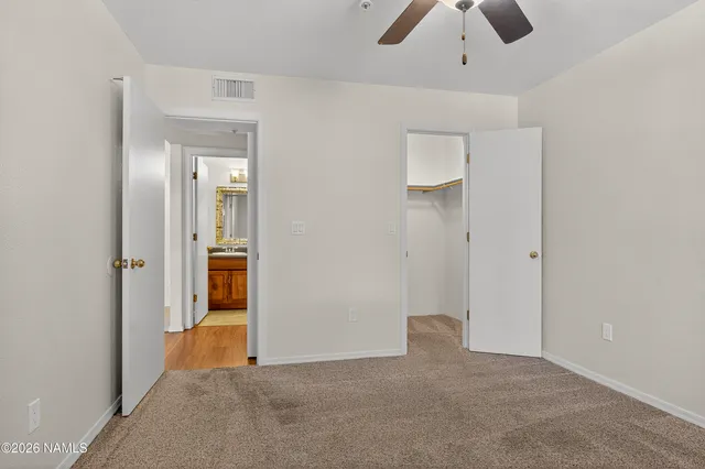 an empty room with closet and chandelier fan