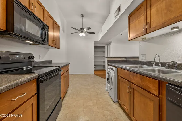 a kitchen with stainless steel appliances granite countertop a sink a stove top oven and cabinetry