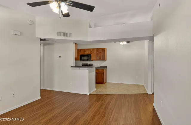 a view of a kitchen with a sink wooden floor and cabinets