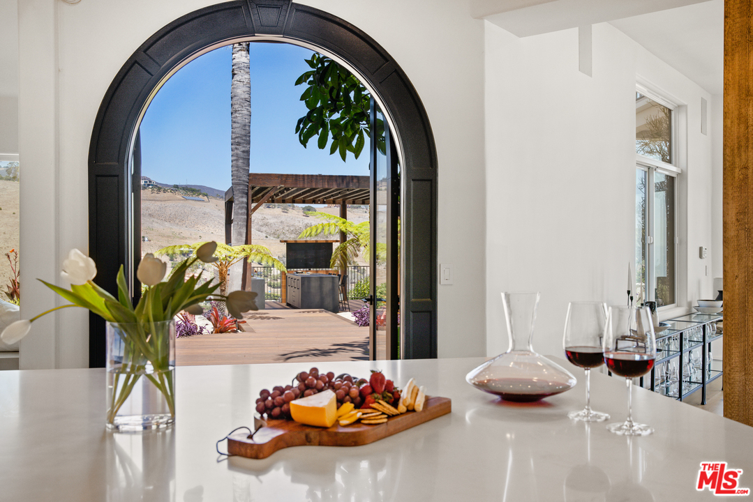 5868 Zumirez Drive Malibu, CA 90265 - Photo 11 of 54 a dining room with furniture potted plants and wooden floor