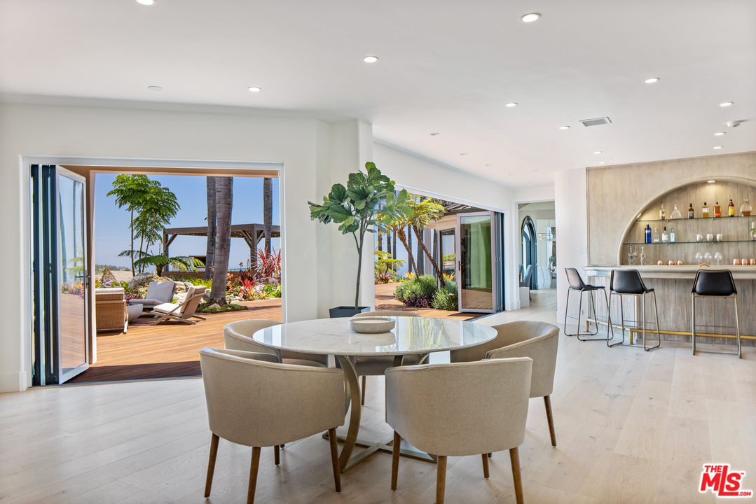 5868 Zumirez Drive Malibu, CA 90265 - Photo 27 of 54 a dining room with furniture and a floor to ceiling window
