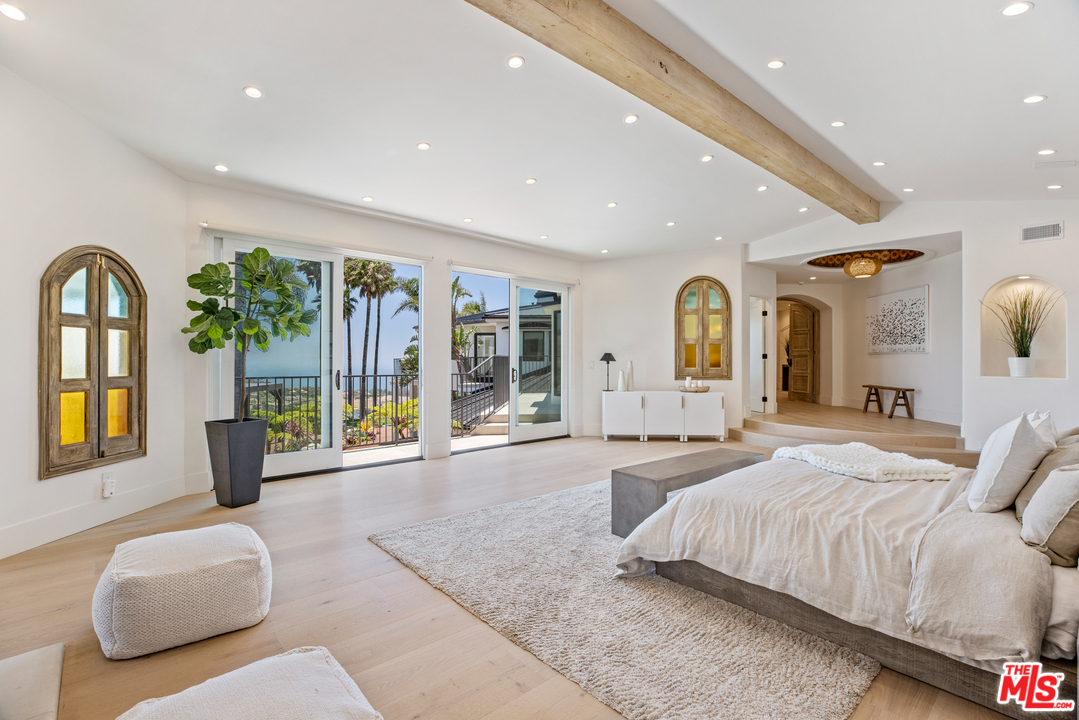 5868 Zumirez Drive Malibu, CA 90265 - Photo 33 of 54 a spacious bedroom with a large bed and large windows