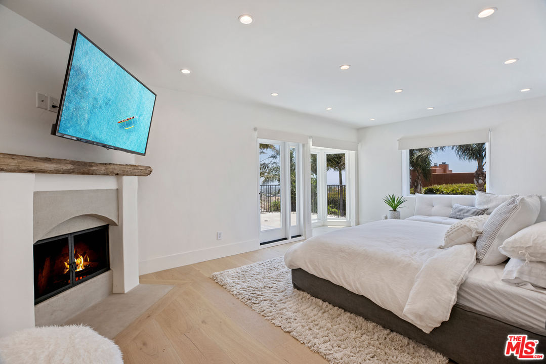 5868 Zumirez Drive Malibu, CA 90265 - Photo 40 of 54 a bedroom with a bed and a fireplace