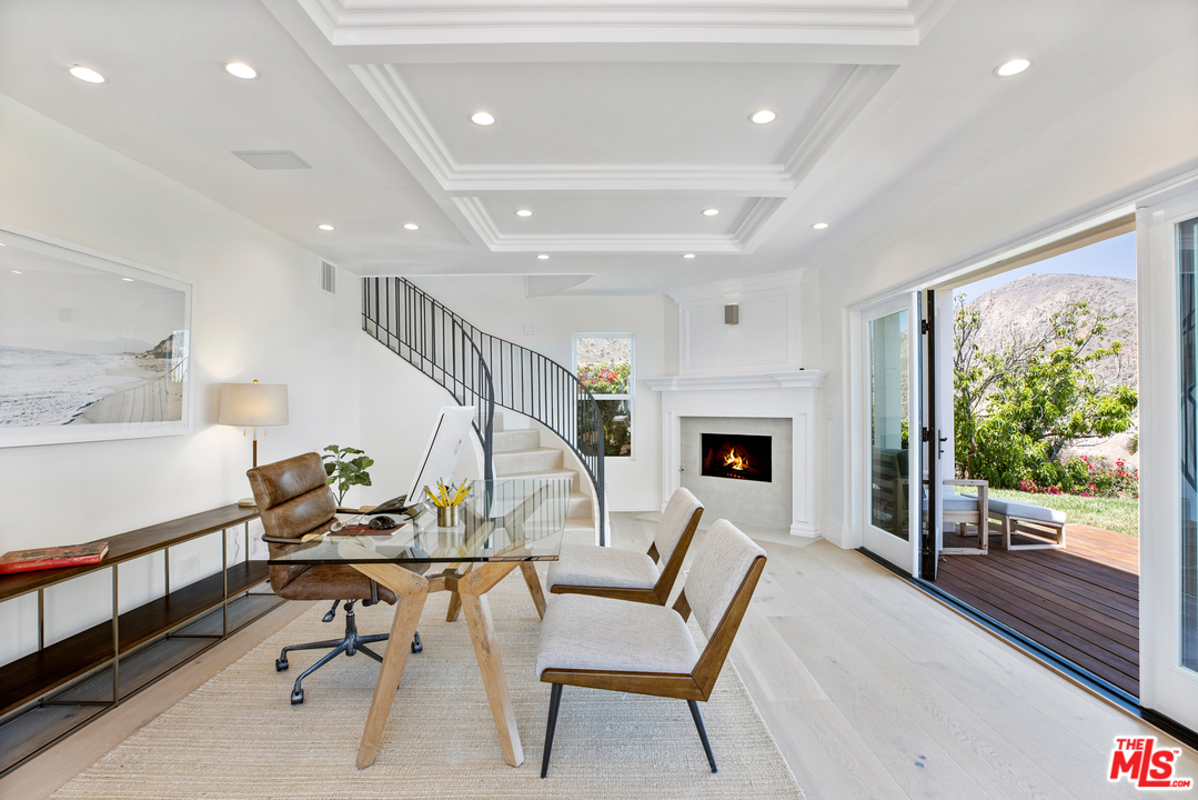 5868 Zumirez Drive Malibu, CA 90265 - Photo 41 of 54 a view of a livingroom with furniture a fireplace wooden floor and windows