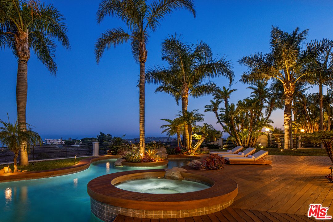 5868 Zumirez Drive Malibu, CA 90265 - Photo 50 of 54 a view of a swimming pool with a table and chairs