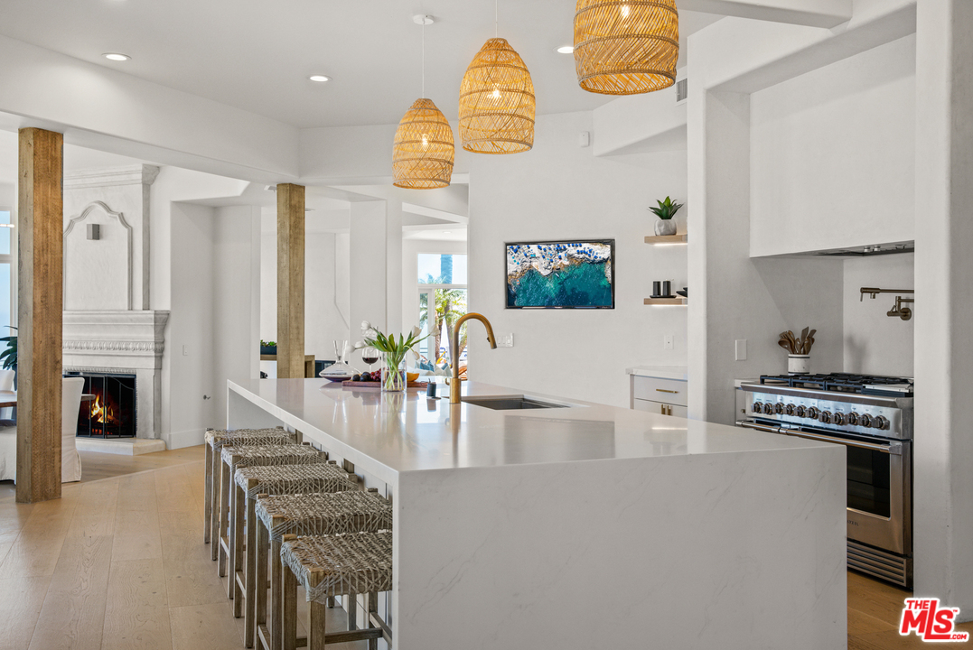 5868 Zumirez Drive Malibu, CA 90265 - Photo 8 of 54 a kitchen with stainless steel appliances granite countertop a stove and a dining table with wooden floor
