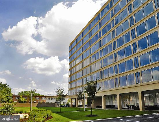 a view of a building with lot of windows and trees