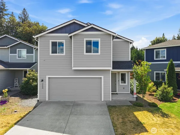 a front view of a house with a yard and garage