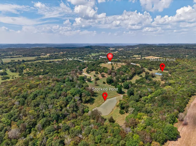 an aerial view of a house with swimming pool and mountains