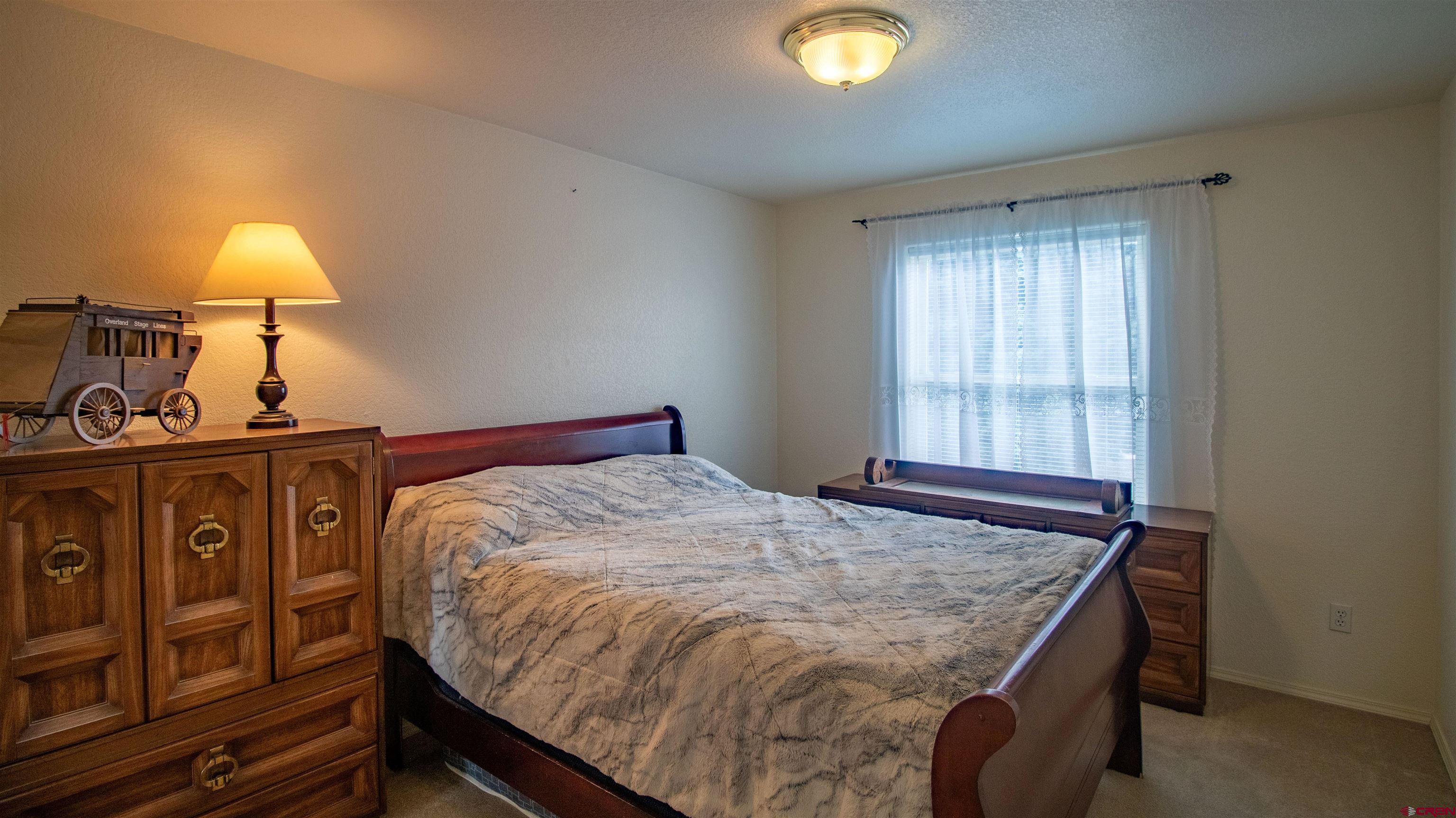 609 Heather Lane Montrose, CO 81401 - Photo 14 of 34 a bed sitting in a bedroom next to a window