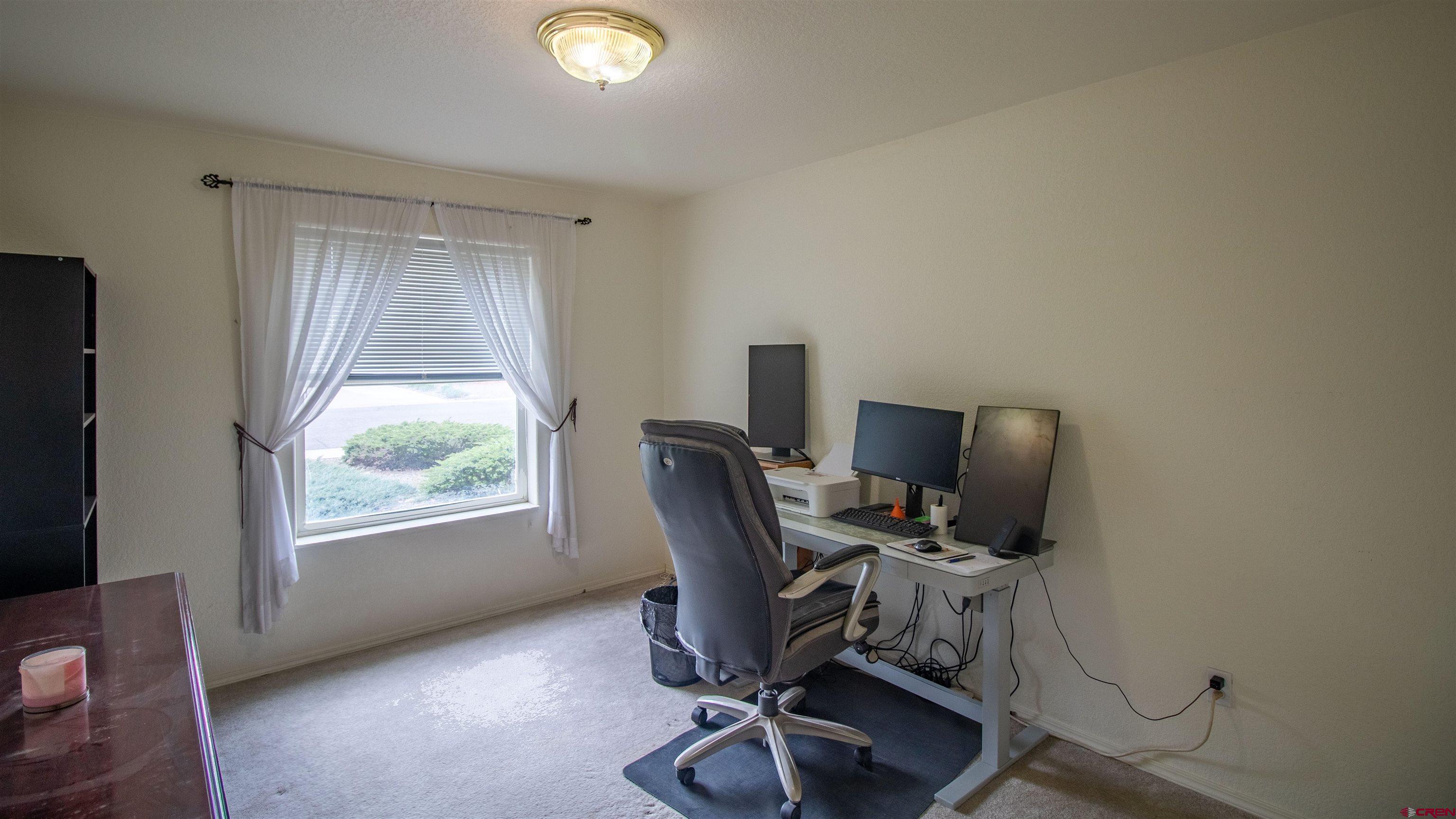 609 Heather Lane Montrose, CO 81401 - Photo 16 of 34 a view of a workspace with furniture and a window