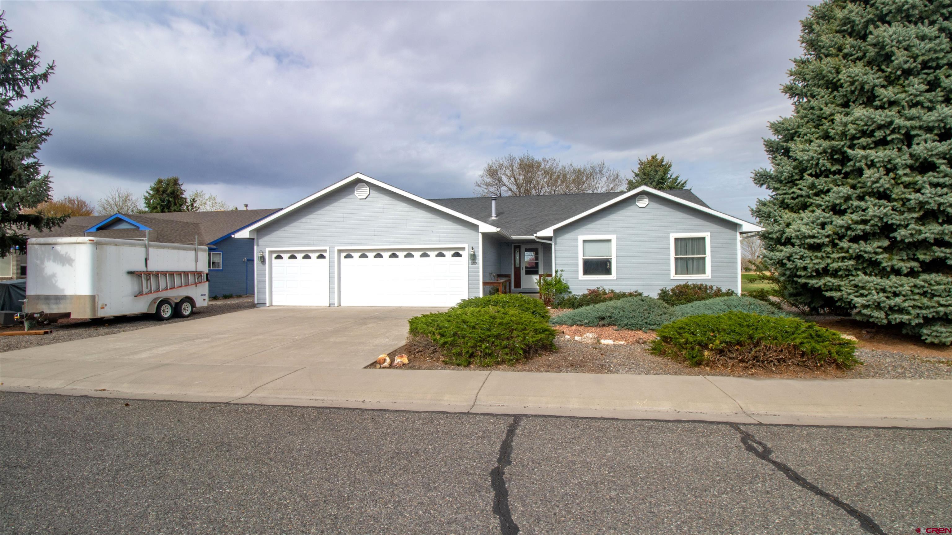 609 Heather Lane Montrose, CO 81401 - Photo 26 of 34 a front view of a house with a yard and garage