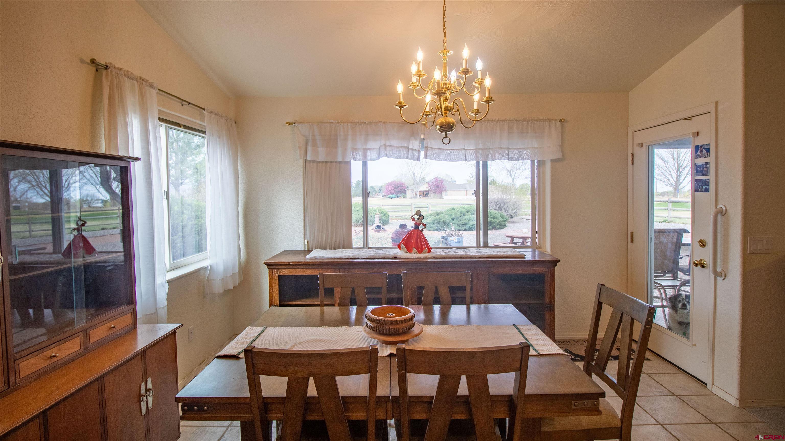 609 Heather Lane Montrose, CO 81401 - Photo 5 of 34 a dining room with furniture a chandelier and wooden floor