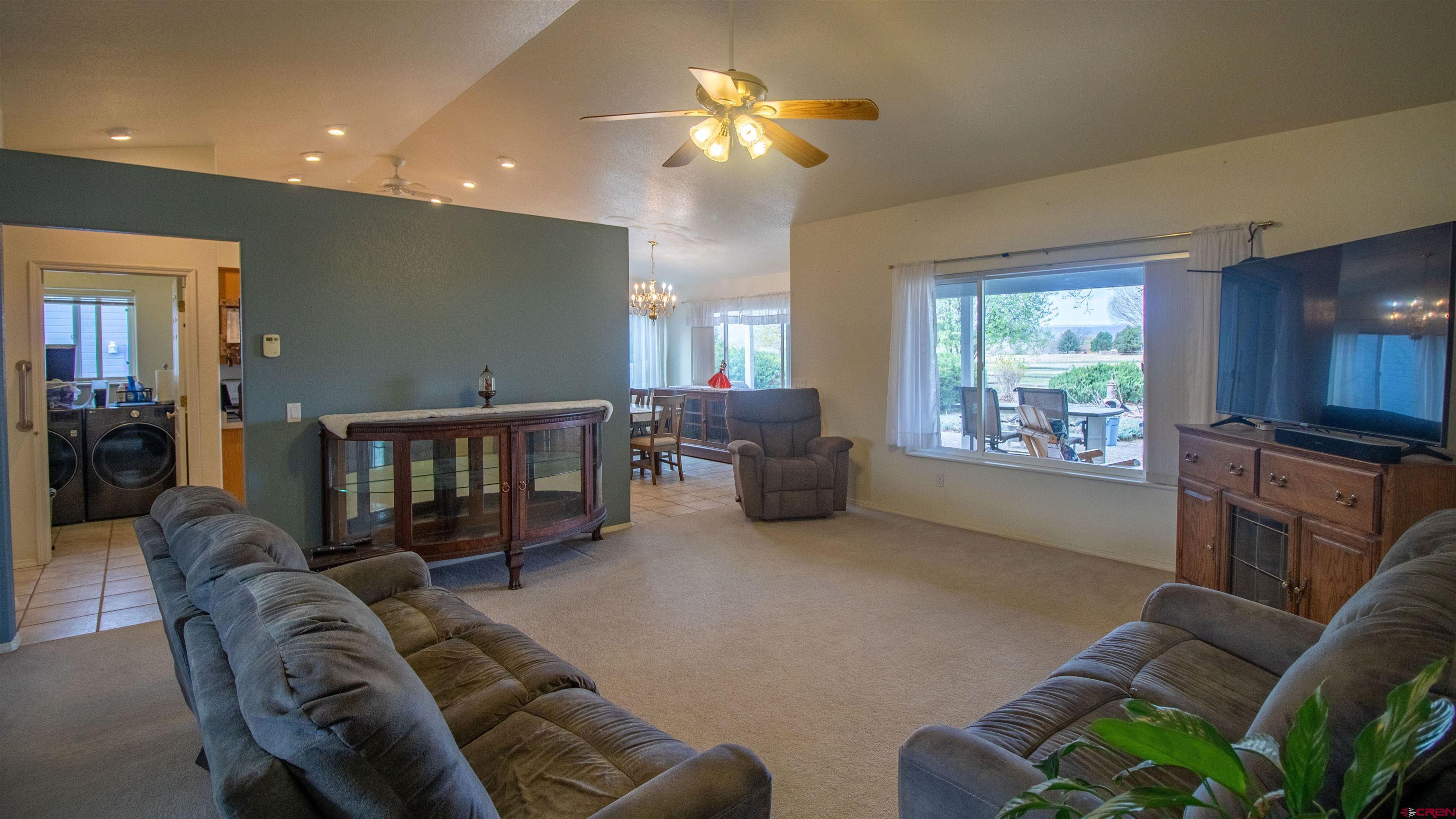 609 Heather Lane Montrose, CO 81401 - Photo 9 of 34 a living room with furniture a window and a chandelier