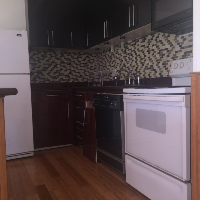 3559 Lower Honoapiilani Road, Unit 718 Lahaina, HI 96761 - Photo 11 of 23 a kitchen with granite countertop white cabinets and black appliances