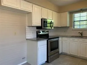a kitchen with white cabinets and a stove