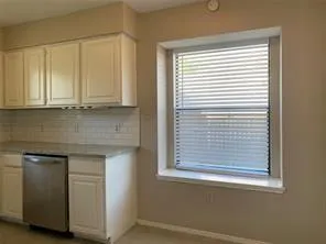 a view of a kitchen with a sink and dishwasher next to a window