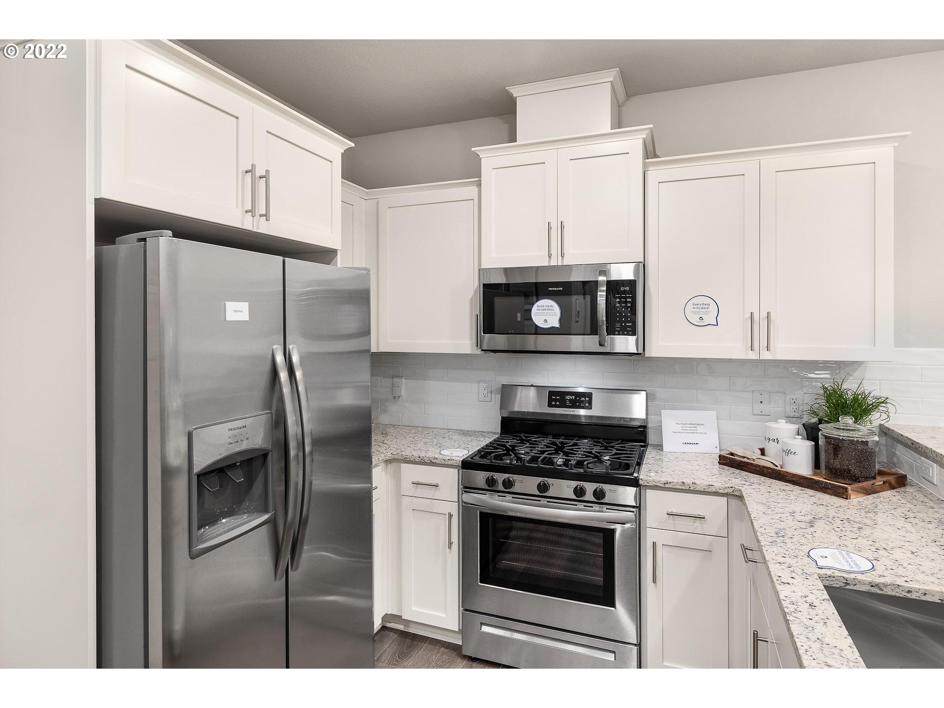 2408 South Brookside Place Ridgefield, WA 98642 - Photo 8 of 32 a kitchen with stainless steel appliances white cabinets a sink and a stove