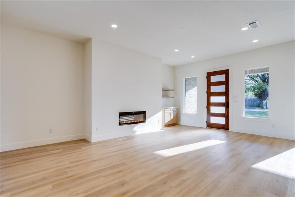 1507 Elk Creek Road Dallas, TX 75253 - Photo 4 of 40 a view of an empty room with window and wooden floor