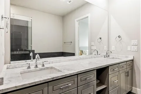 a bathroom with double sink and a mirror