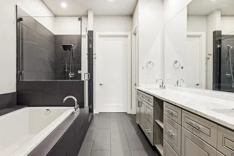 a bathroom with a tub sink shower and mirror