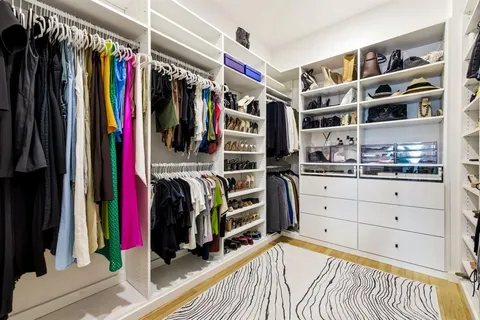 a view of walk in closet with clothes and shoes