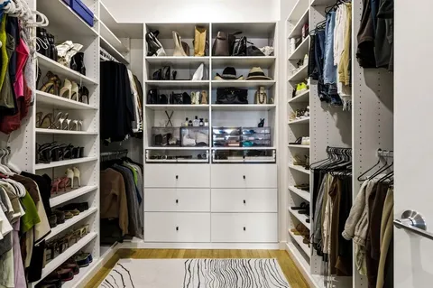 a view of walk in closet with clothes and shoes