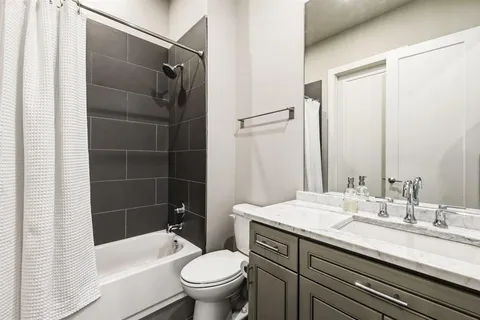 a bathroom with a granite countertop sink toilet and shower