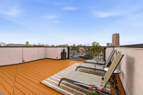 a view of roof deck with two chairs and a floor to ceiling window