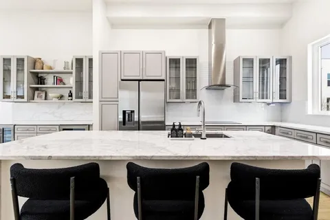 a kitchen with stainless steel appliances granite countertop a sink and white cabinets