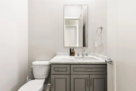 a bathroom with a toilet sink and mirror