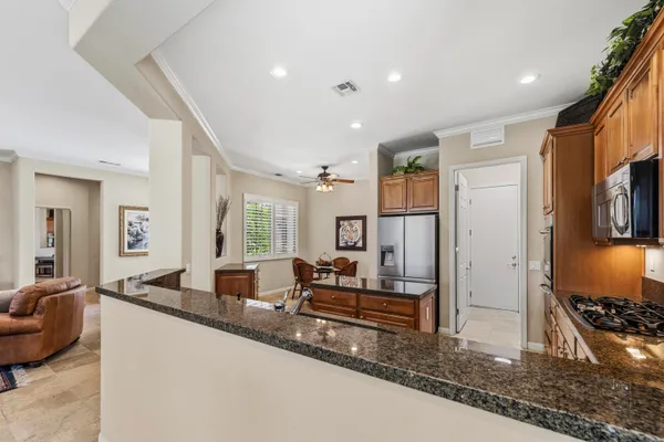 a large living room with stainless steel appliances granite countertop furniture and a fireplace