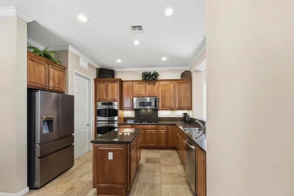 a kitchen with stainless steel appliances granite countertop a refrigerator and a stove