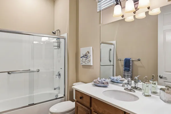 a bathroom with a sink vanity granite toilet and shower