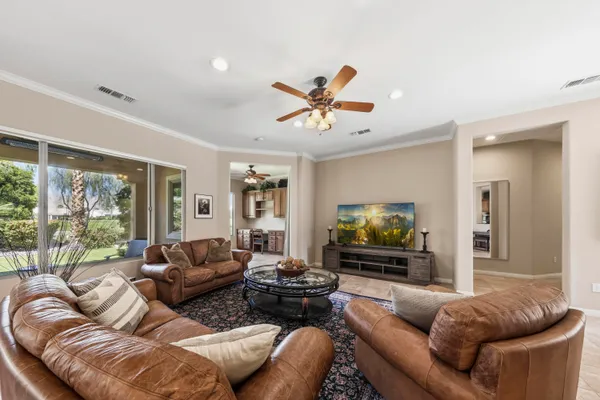a living room with furniture ceiling fan and a large window